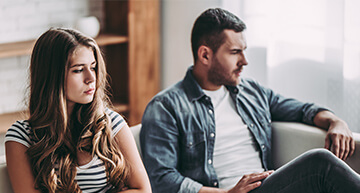 Young teenage girl sitting angerly next to her father | Depression